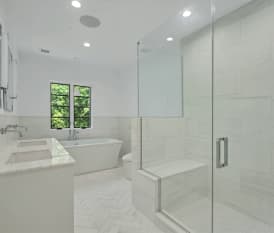 Remodeled bathroom with white tile floors, double vanity, and separate shower and tub.