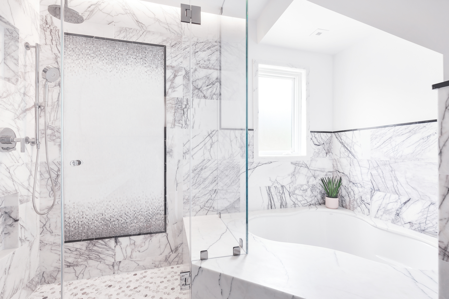 Bathroom remodel with marble walls and white bath.